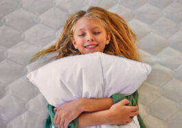 jaki materac dla dziecka - dziecko na materacu z poduszką