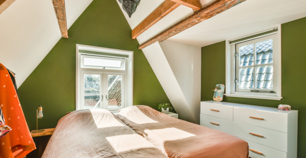 sypialnia na poddaszu z zielonymi ścianami