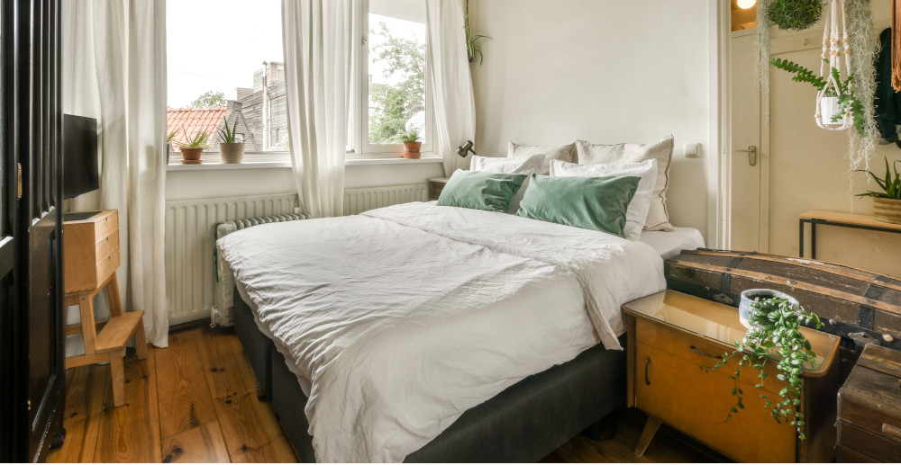 aranżacja przytulnej sypialni z tapicerowanym łóżkiem