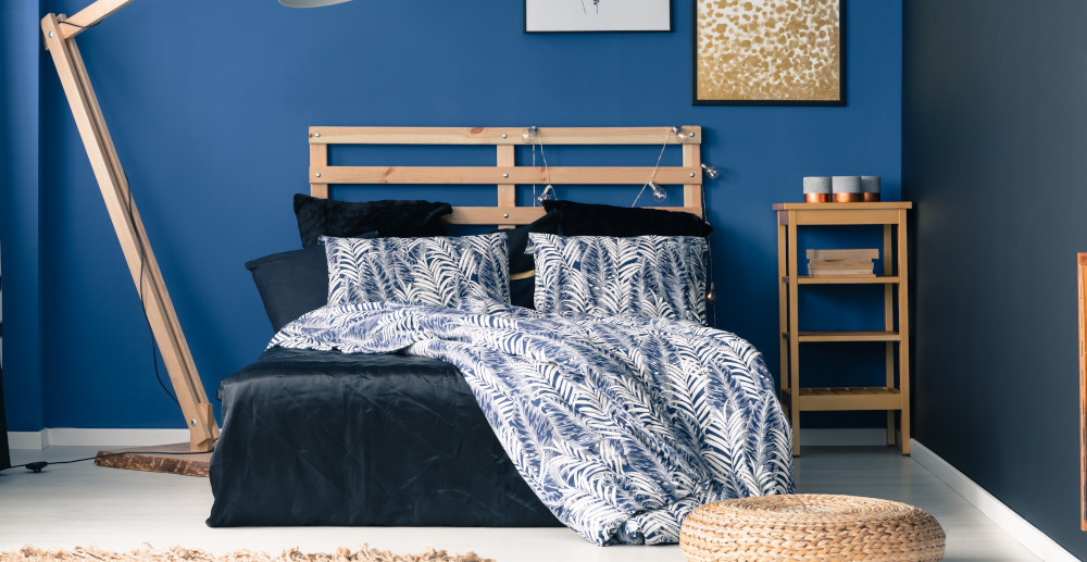 niebieska ściana w sypialni za łóżkiem